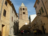 Da una vietta di Alghero, ci si dirige verso la chiesa. In alto svetta il campanile che va ad immergersi nel cielo azzurro!