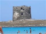 Dalla spiaggia di stintino, si vede oltre il mare blu' l'isolotto che ospita la torre di avvistamento.