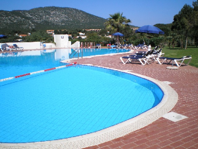 L'immensa piscina dell'hotel Capo Caccia tra monti verdeggianti