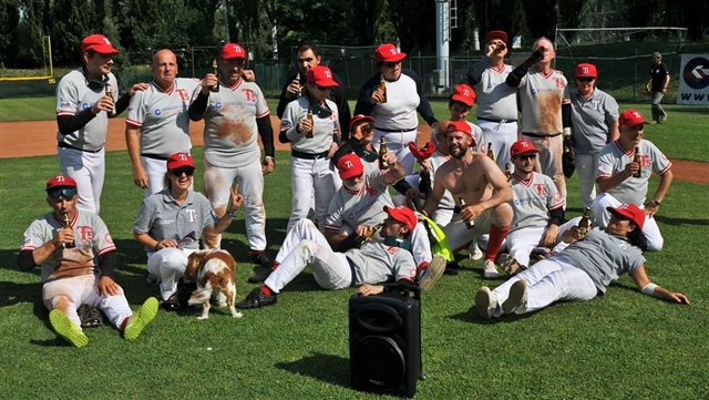 Tutta la squadra chi in piedi chi sdraiati con birra che festeggia.