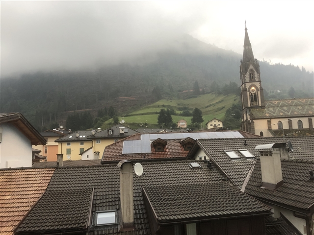 Cielo cupo e nebbioso oltre la chiesetta di Predazzo.