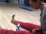 Simona controlla gli atleti dal telefono mentre fa ginnastica.