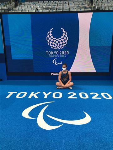 Martina Seduta A Gambe Incrociate Con Lo Sfondo Il Logo Della Paralimpiadi E Davanti La Scritta Tokyo 2020