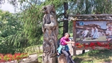 Coccolina vicina ad una scultura che rappresenta un orso.
