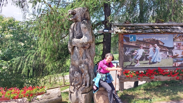 Coccolina vicina ad una scultura che rappresenta un orso.